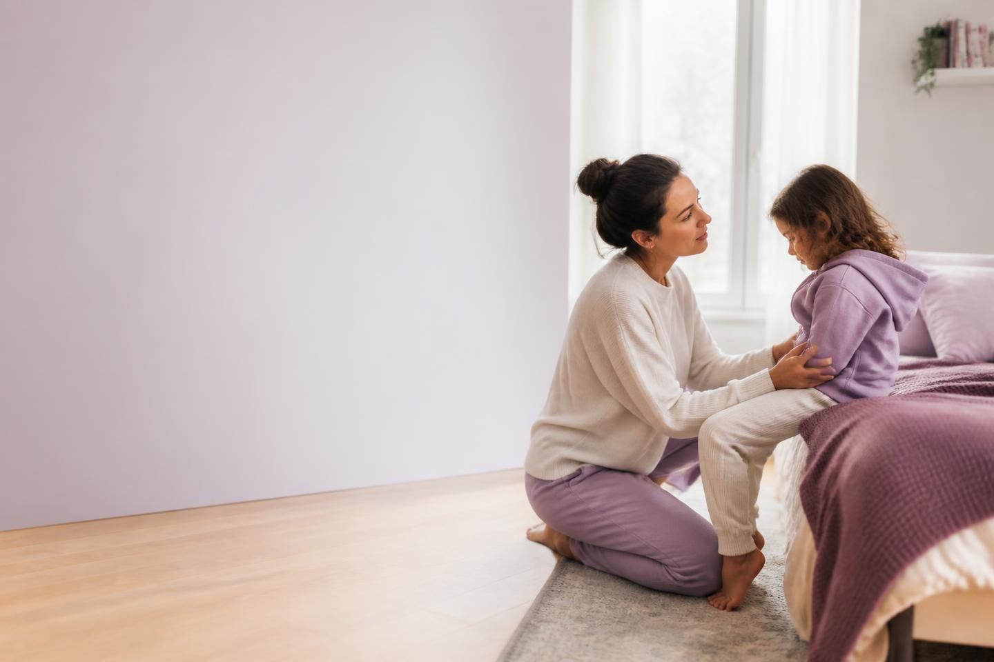 Mamá acompañando con calma a su hija pequeña en un momento emocional